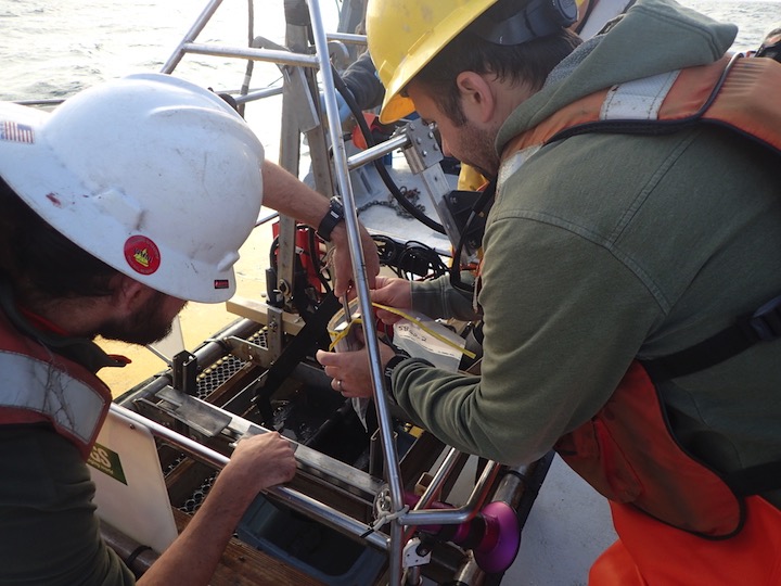 Researchers taking a sediment grab for grain size analysis.